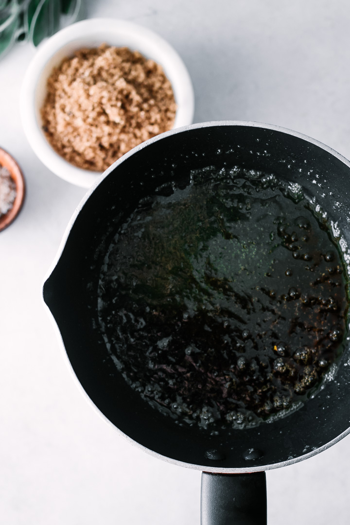 A sauce pan with brown sugar, sage, and maple syrup