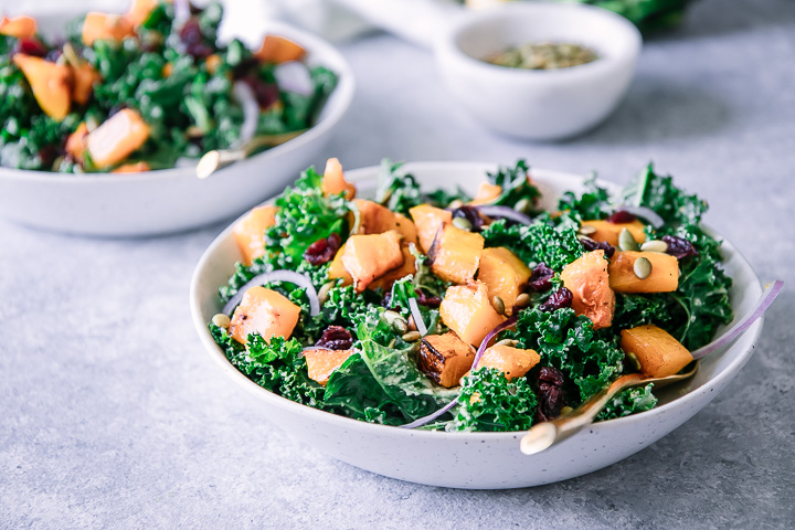 Kale salad with butternut squash in a white bowl