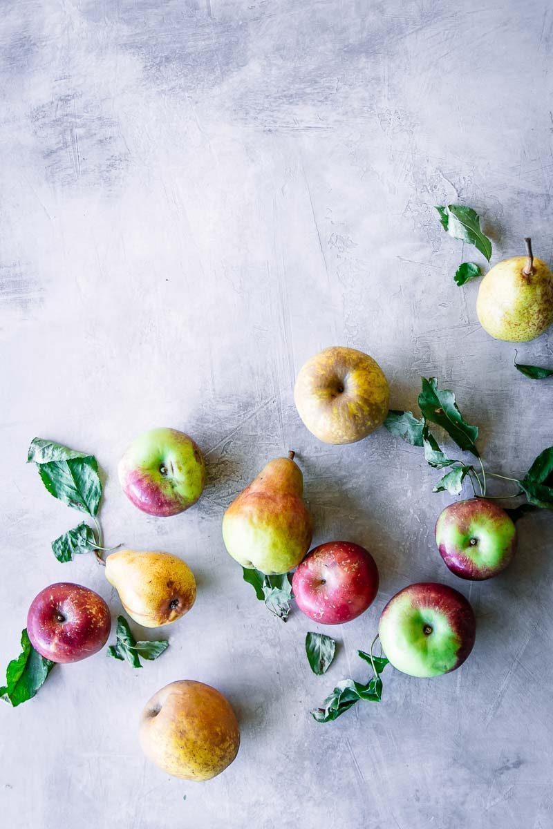 assorted green, red, and yellow apples on a blue-grey table