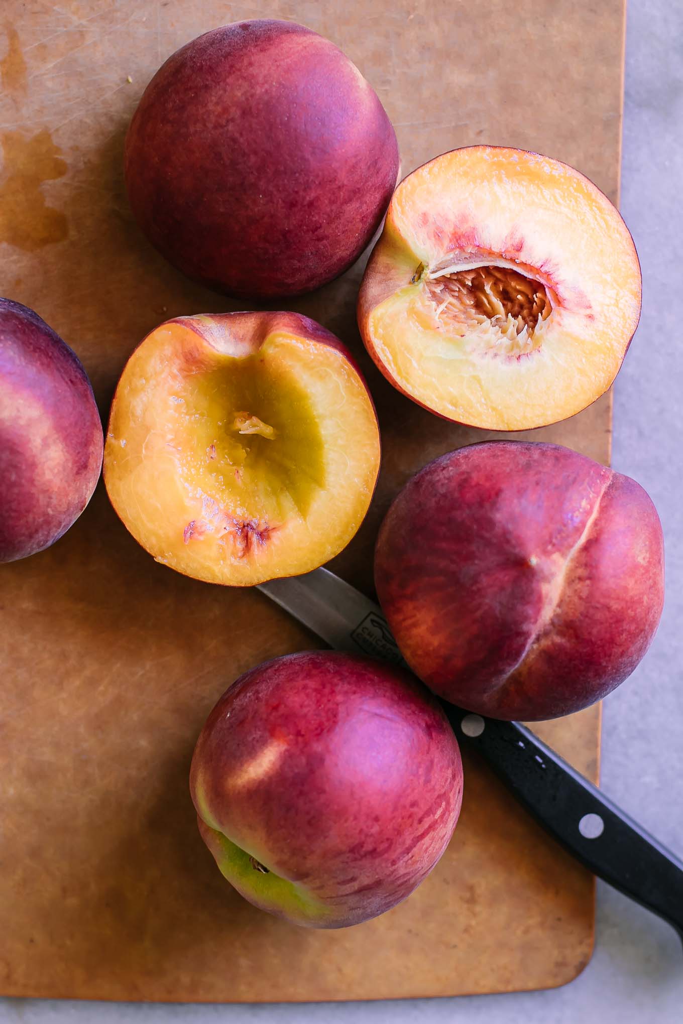 sliced peaches on a wood cutting board