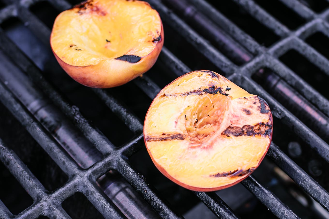 grilled peach halves on a barbecue grill