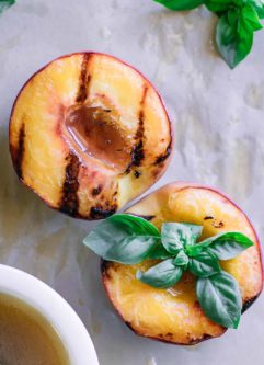 grilled peaches on a wood table with brown sugar bourbon sauce