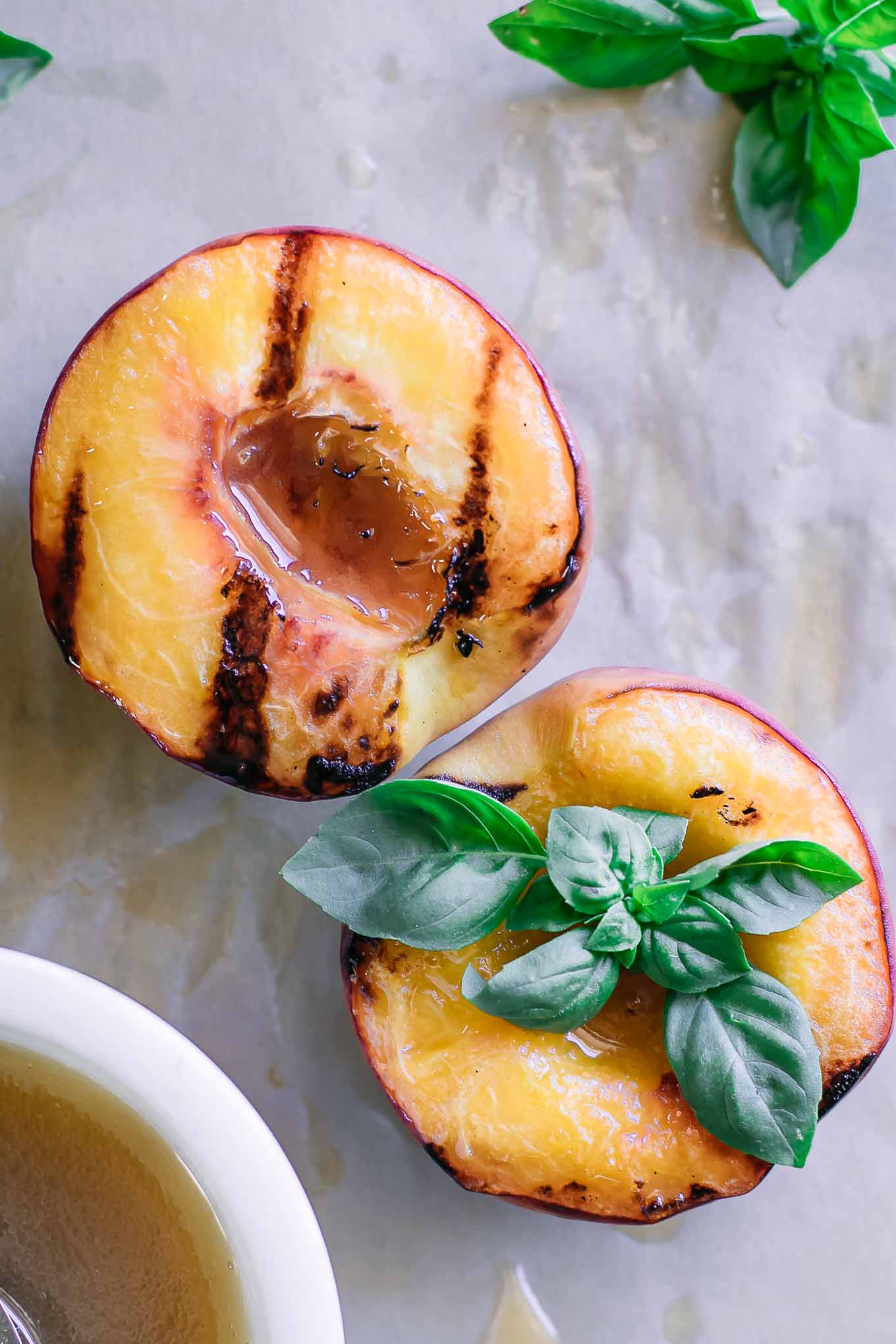 grilled peaches on a wood table with brown sugar bourbon sauce