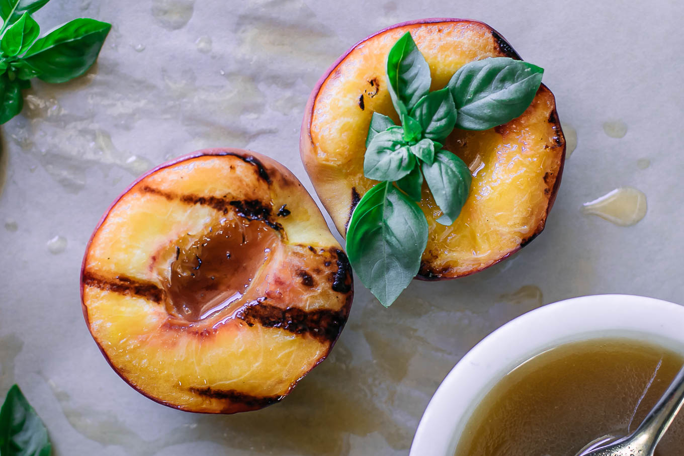 grilled peach halves on a table with drizzled sauce