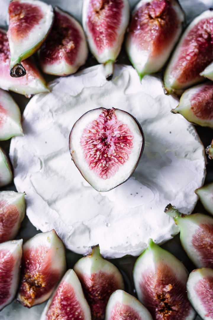 A close up shot of figs on top of brie.