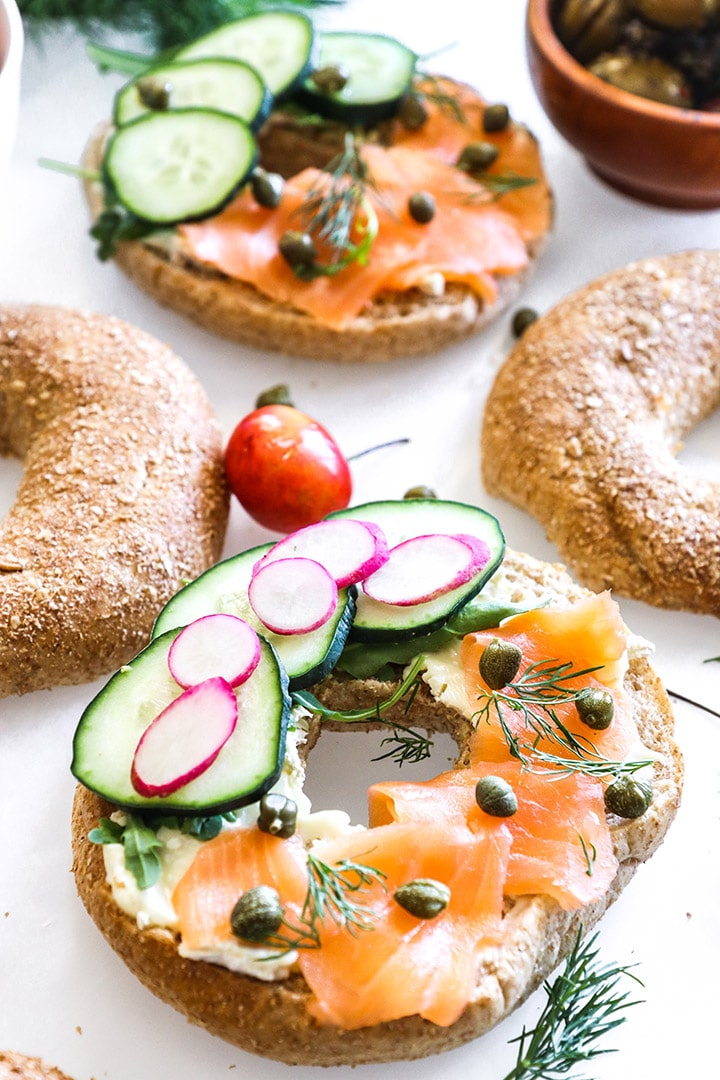 a bagel with smoked salmon and cream cheese on a white table