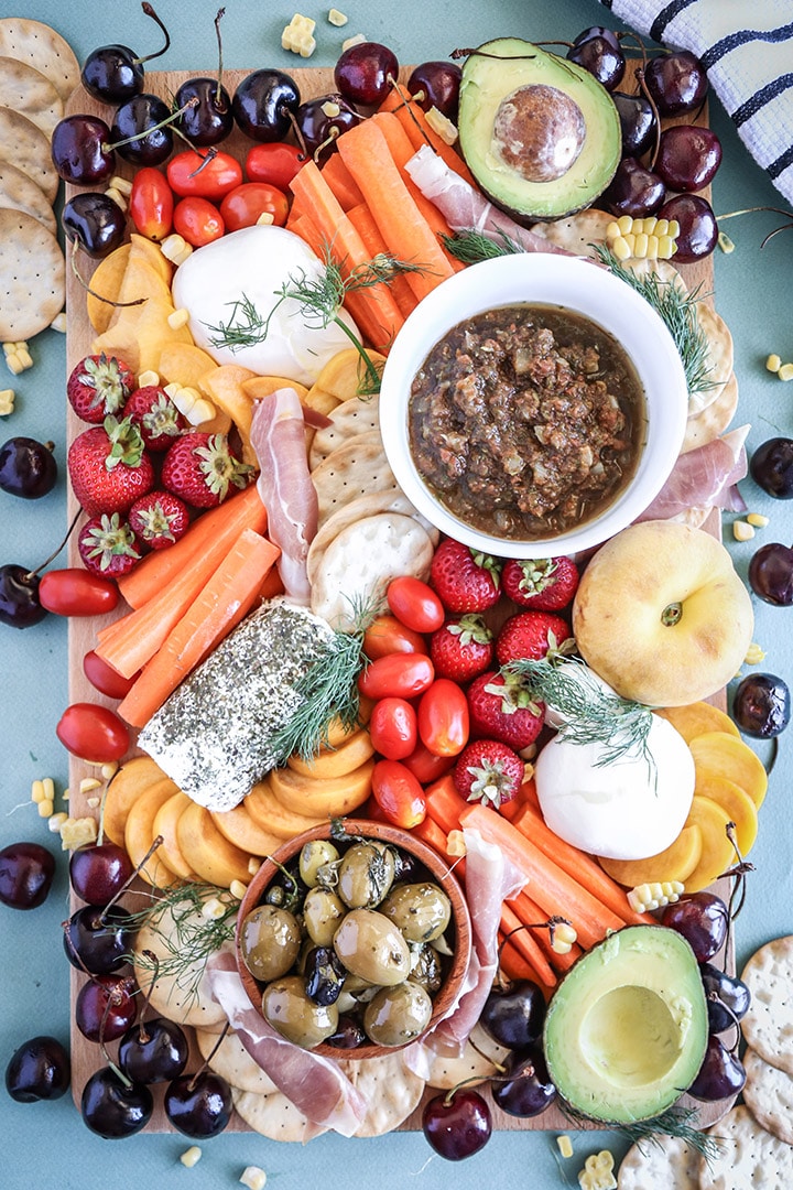 An easy summer crudite platter with sliced veggies, seasonal fruit, creamy cheeses and fresh herbs. Basically summer on a plate!