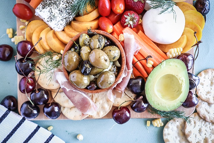 An easy summer crudite platter with sliced veggies, seasonal fruit, creamy cheeses and fresh herbs. Basically summer on a plate!