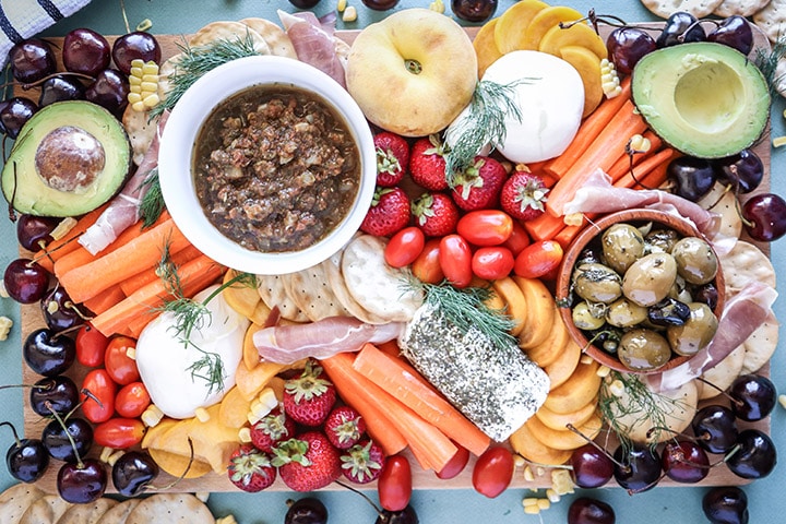 An easy summer crudite platter with sliced veggies, seasonal fruit, creamy cheeses and fresh herbs. Basically summer on a plate!