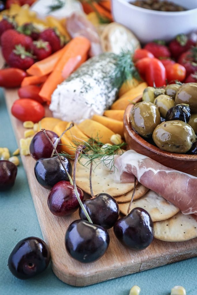 An easy summer crudite platter with sliced veggies, seasonal fruit, creamy cheeses and fresh herbs. Basically summer on a plate!