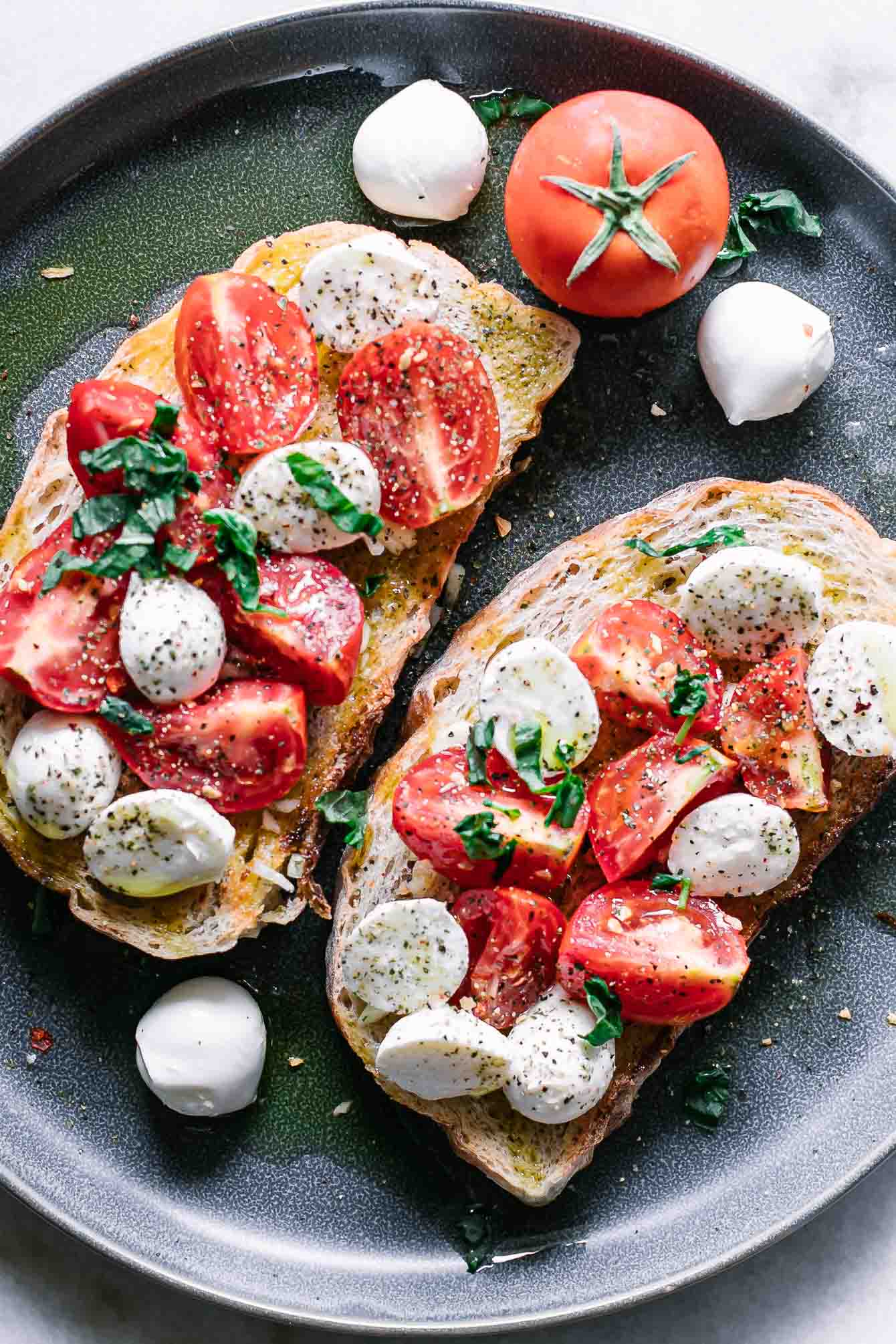 tomatoes, mozzarella, and basil on ciabatta toast on a blue plate