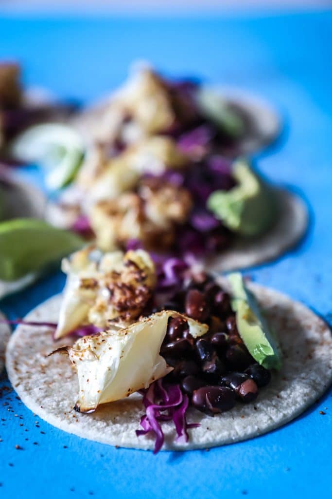 Chili lime Cauliflower Tacos made with roasted cauliflower, chili powder, fresh lime, black beans and avocado. A vegan take on Taco Tuesday!