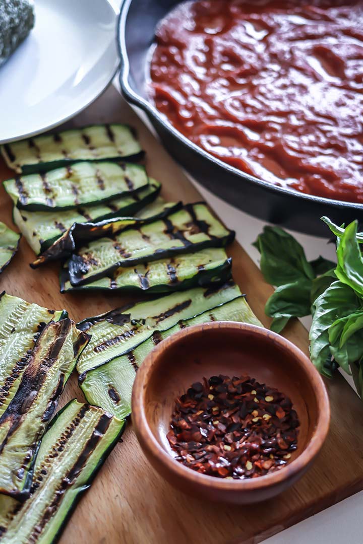 Grilled Zucchini Goat Cheese Bake - zucchini stuffed with herbed goat cheese and baked with marinara sauce. Serve with fresh bread for an easy dinner!