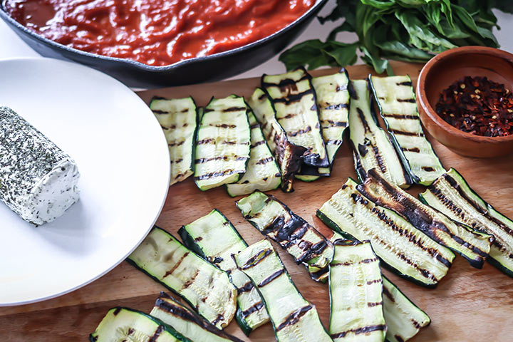 Grilled Zucchini Goat Cheese Bake - zucchini stuffed with herbed goat cheese and baked with marinara sauce. Serve with fresh bread for an easy dinner!