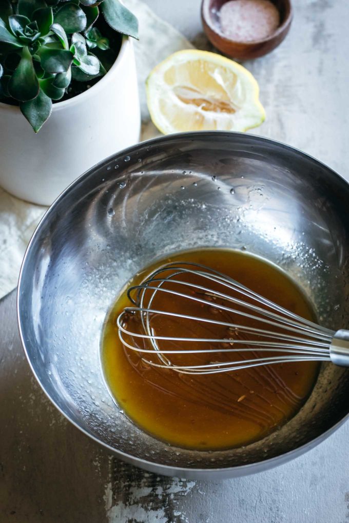 Whisk and oil inside a metal bowl 