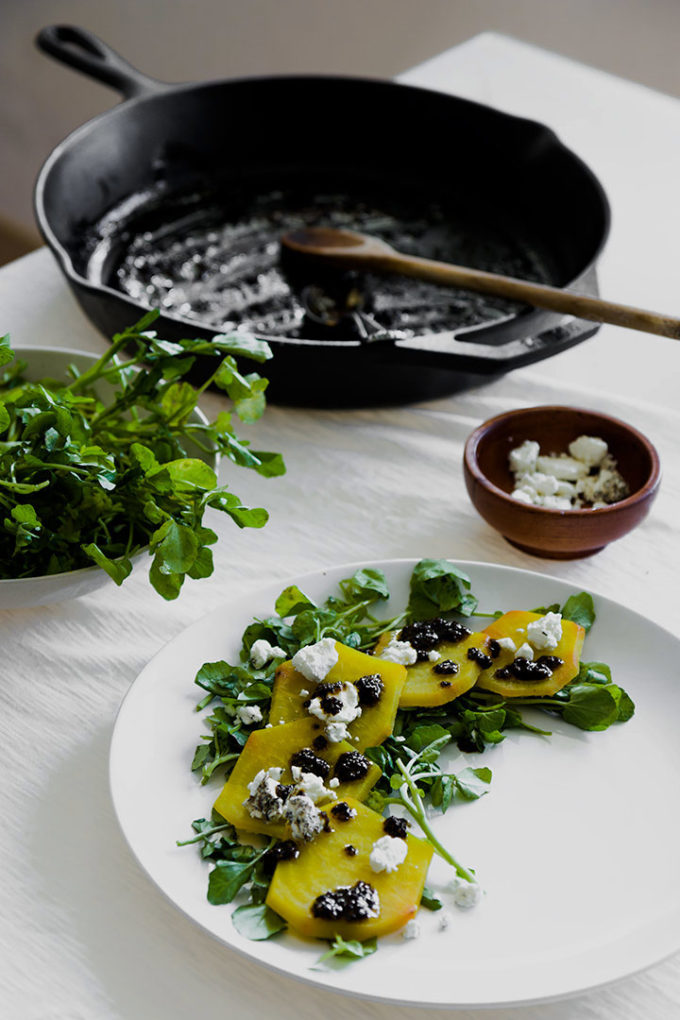 roasted golden beet carpaccio on a white place with a white table.