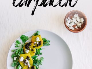 roasted golden beet carpaccio on a white place with a white table.