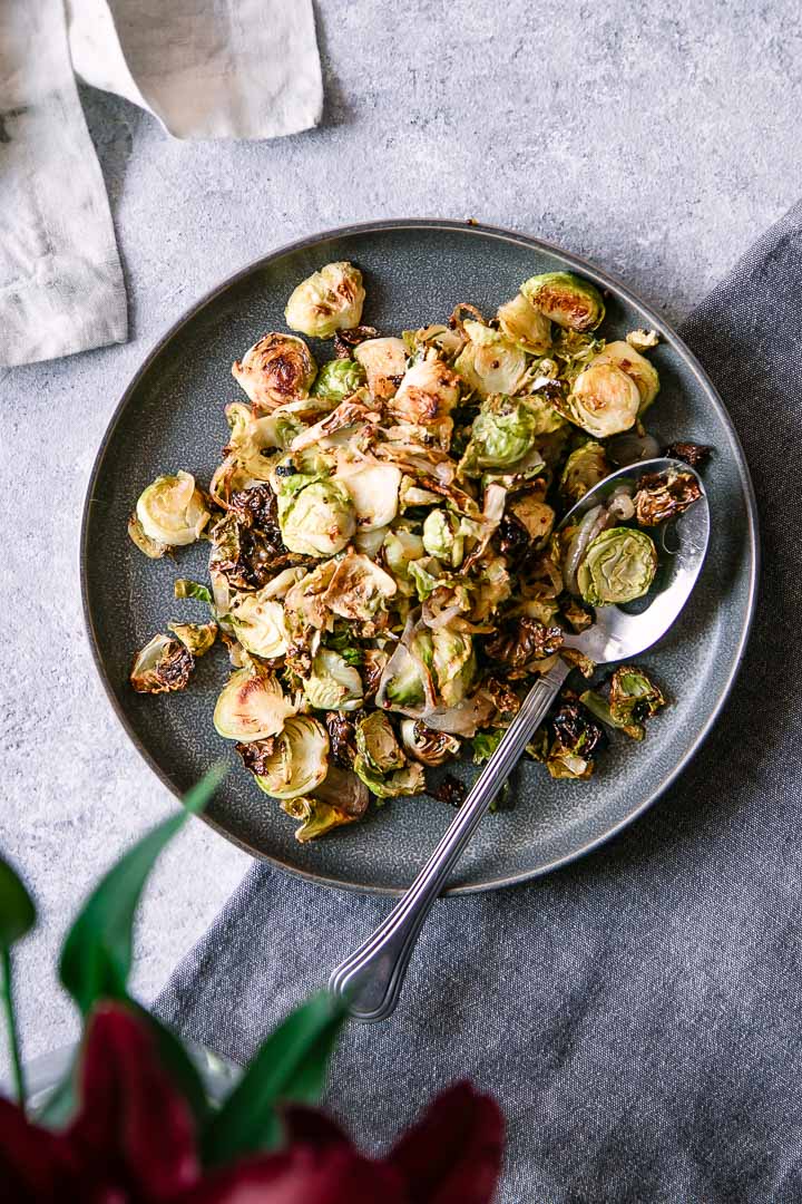 crispy roasted brussels sprouts with maple syrup and mustard on a blue plate