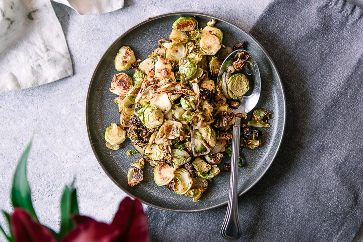 A simple brussels sprouts side dish on a white table for Thanksgiving