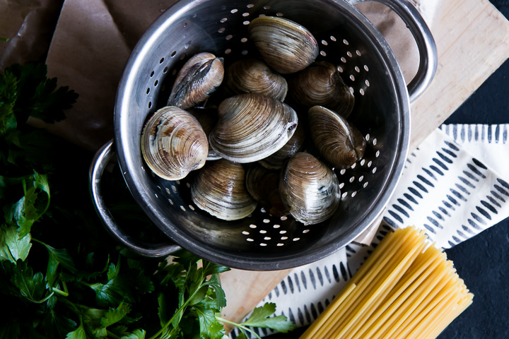 clams in a colander with parsley and spaghetti pasta noodles