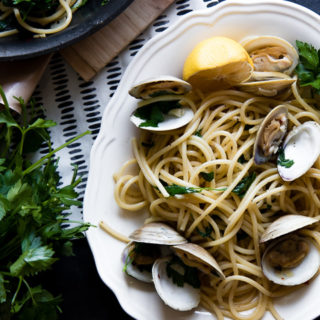 a plate of pasta with clams (pasta con vongole) with fresh parsley