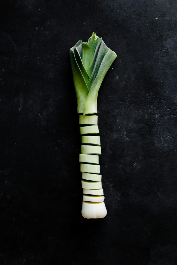 a sliced leek on a black table