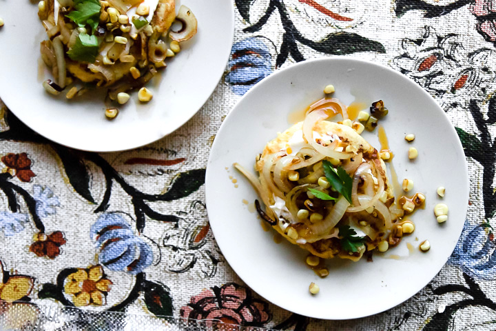 Colombian spicy vegetable recipe on a white plate with spicy roasted vegetables on a colorful patterned background.