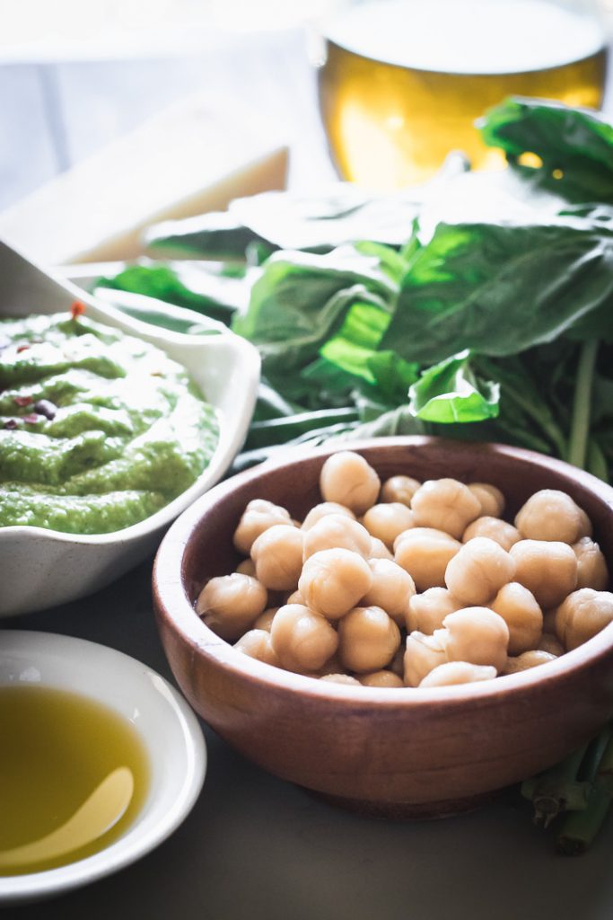 chickpeas on a white plate on a wooden table with a napkin.