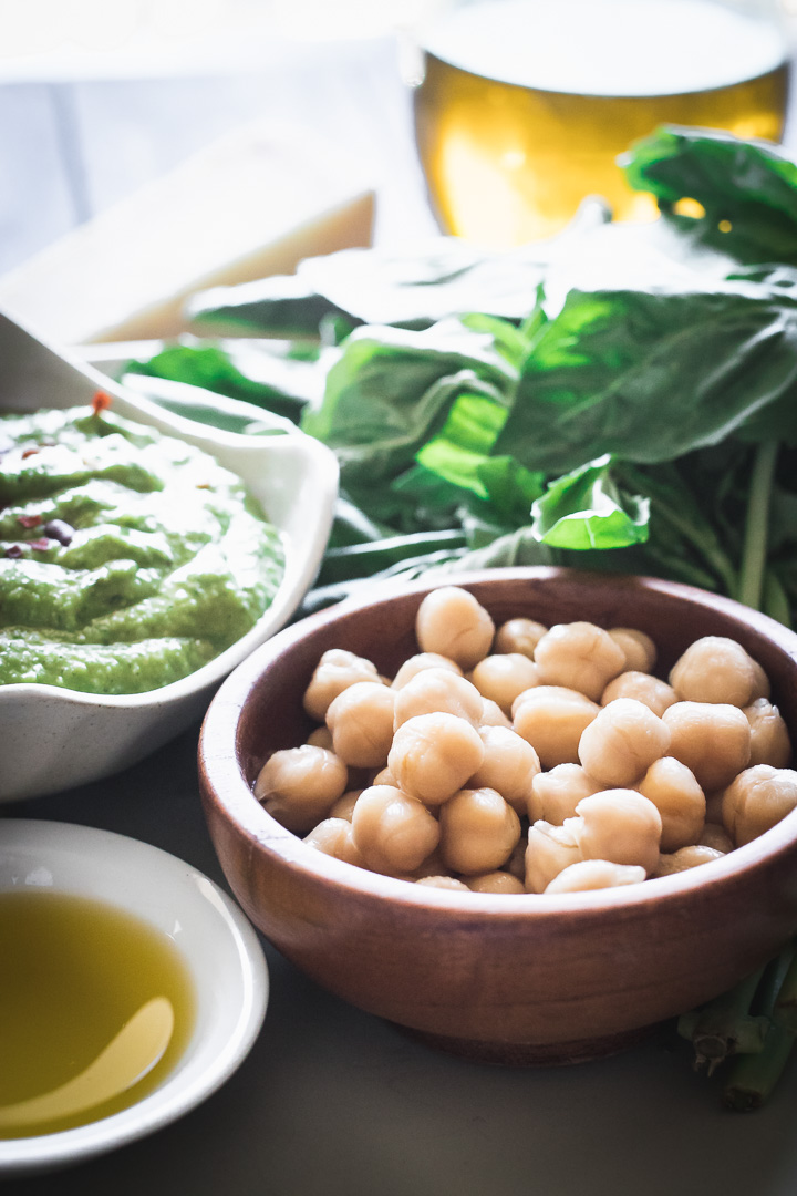 chickpeas on a white plate on a wooden table with a napkin.