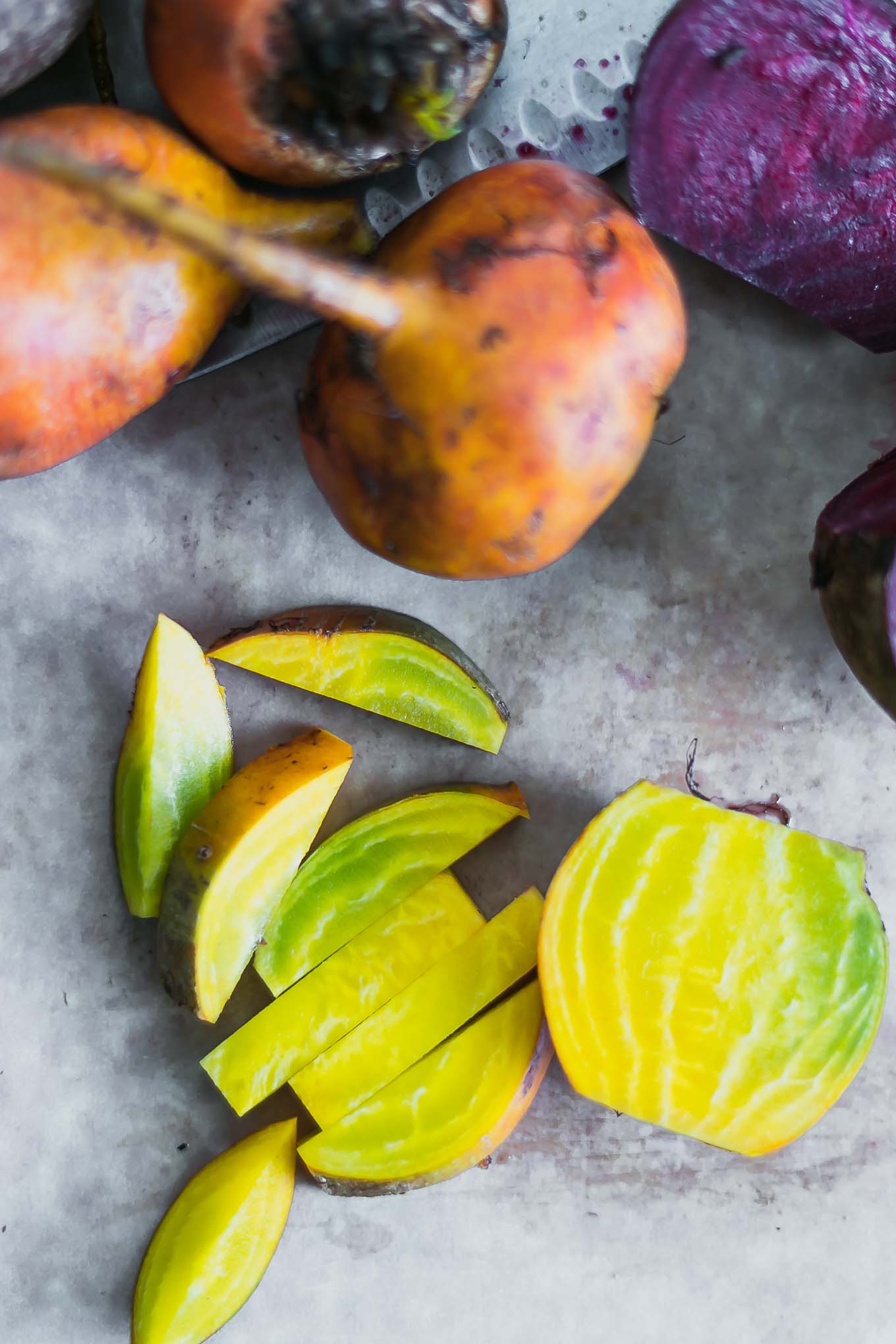 cut golden beets on a white cutting board