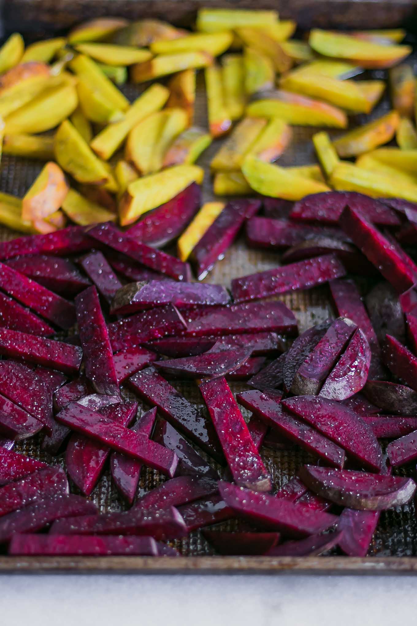 cut red and golden beets on a baking sheet