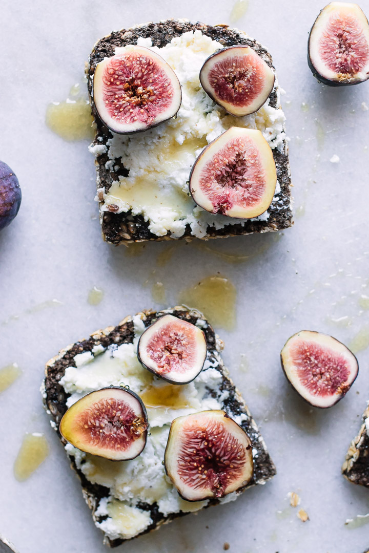 Wheat toast with ricotta cheese, figs, honey, and salt on marble.