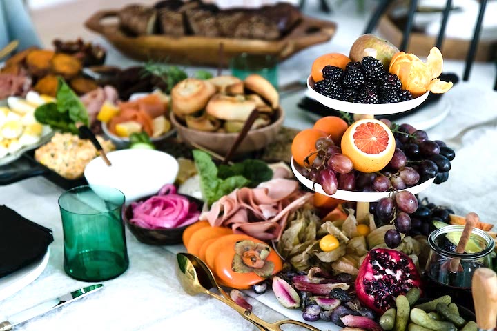 A brunch platter on a white table with a plate and glass.