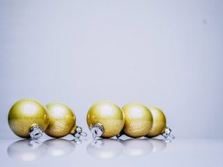 gold holiday ornaments on a white table