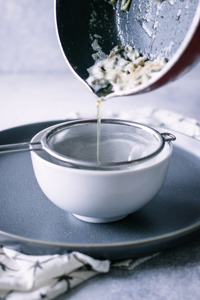 brown butter pouring through a strainer