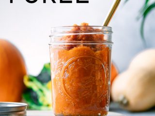 A jar of homemade pumpkin puree on a blue table