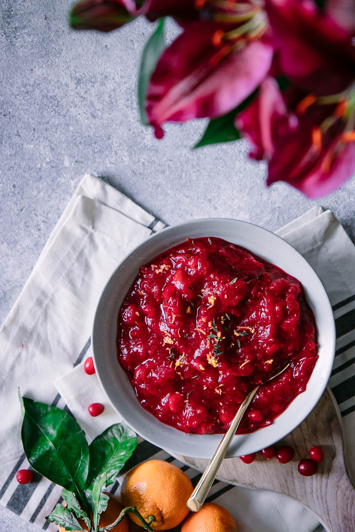 A bowl of red cranberry sauce on a Thanksgiving table