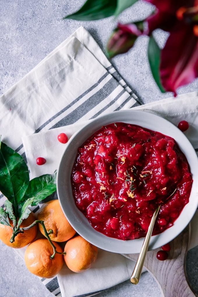 Cranberry compote on a table with oranges and flowers