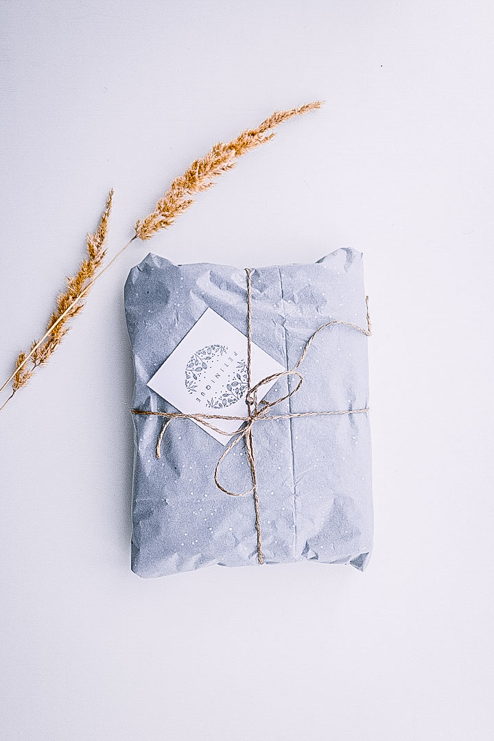 A blue gift-wrapped present with a twig of hay