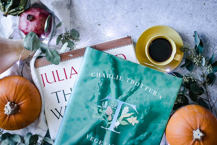 julia child and charlie trotter seasonal cookbooks on a blue table