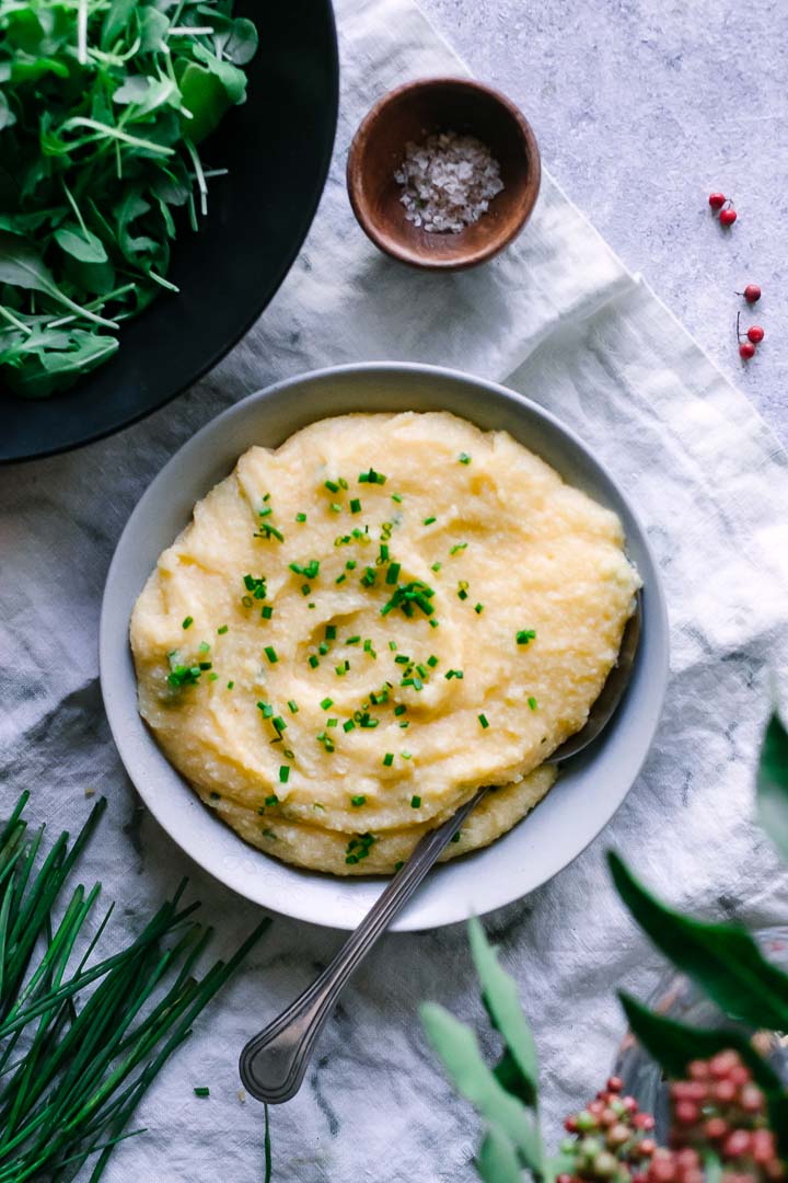 a bowl of cheddar chese polenta on a blue table