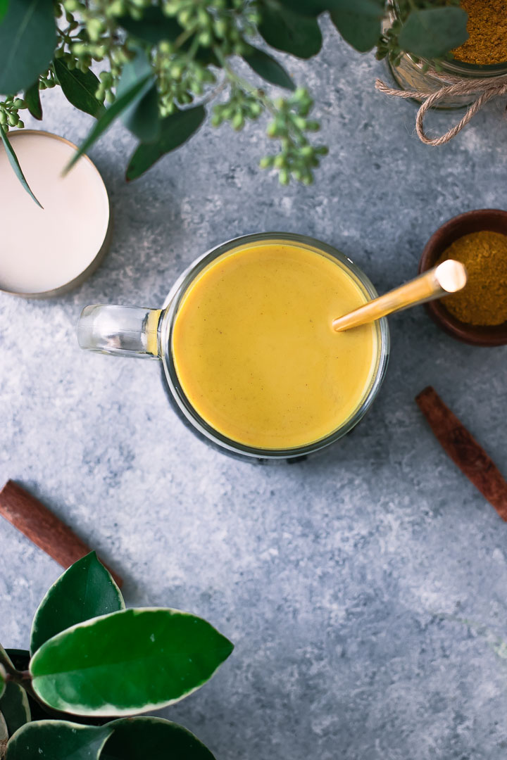 a yellow turmeric latte with cinnamon sticks