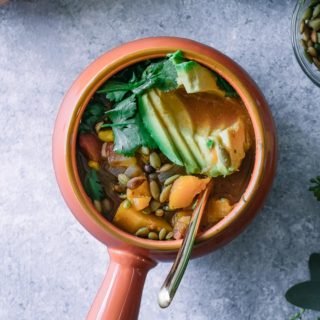 butternut squash chili in an orange soup bowl with a gold spoon