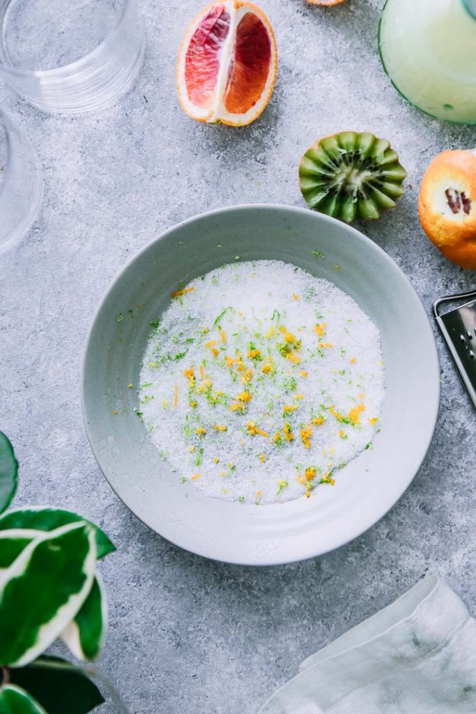 a round grey bowl with margarita salt made from kosher salt, lime zest, and orange zest on a blue table