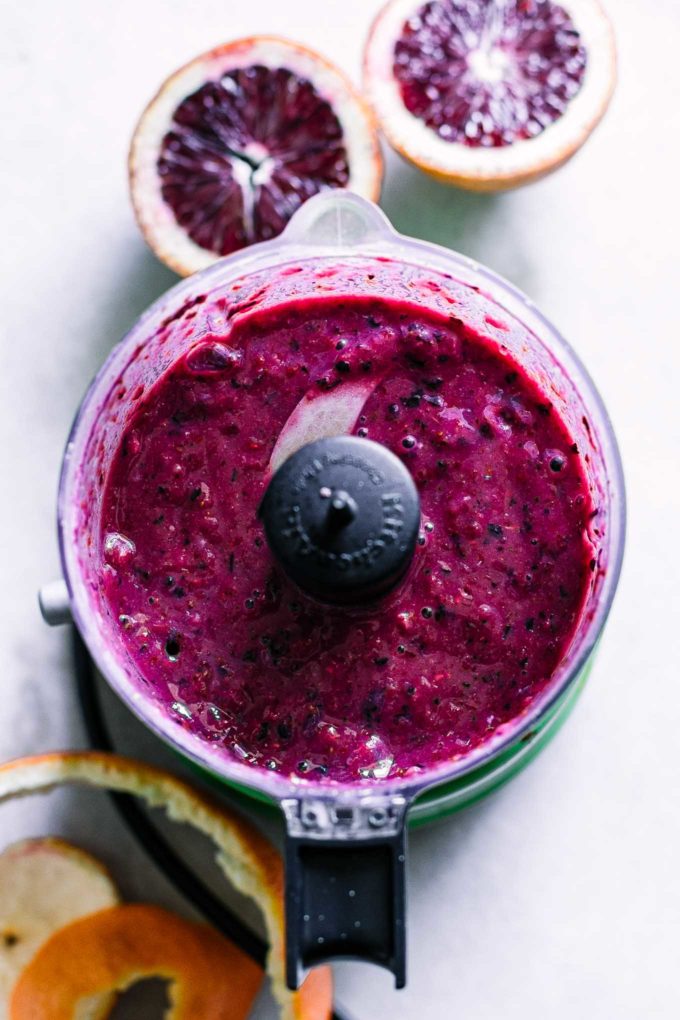 a blood orange smoothie with berries blended inside a blender