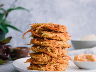 vegetable cakes stacked on top of one another on a white plate with the words "turnip carrot cakes with garlic aioli" in black writing