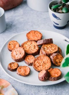 crispy vegan sweet potato wedges on a white plate on a blue table