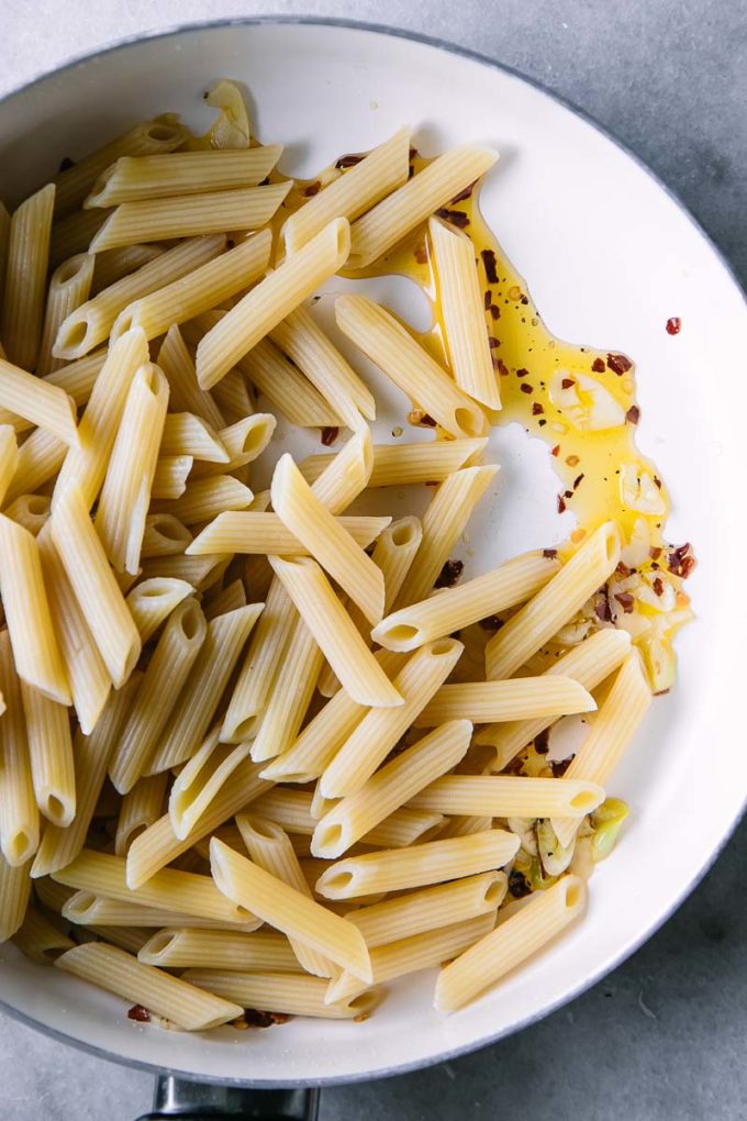 penne pasta in an pan with spicy olive oil