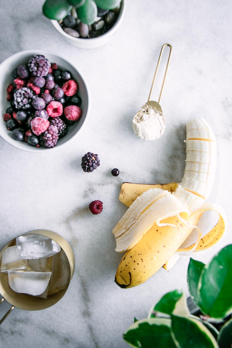 a sliced banana on a table with berries for smoothie