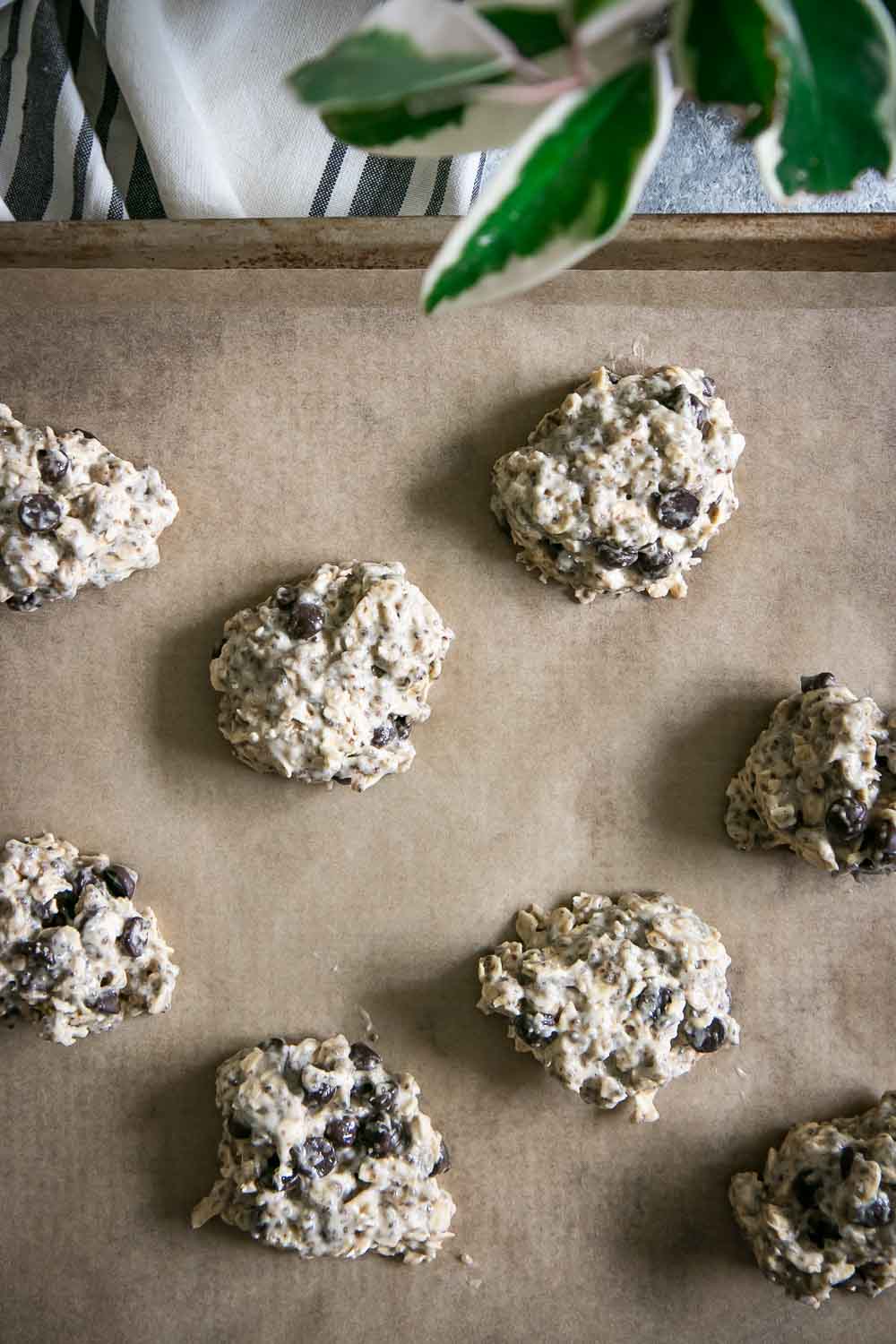 chilled vegan oatmeal chocolate cookie dough on a baking sheet with recycled parchment paper